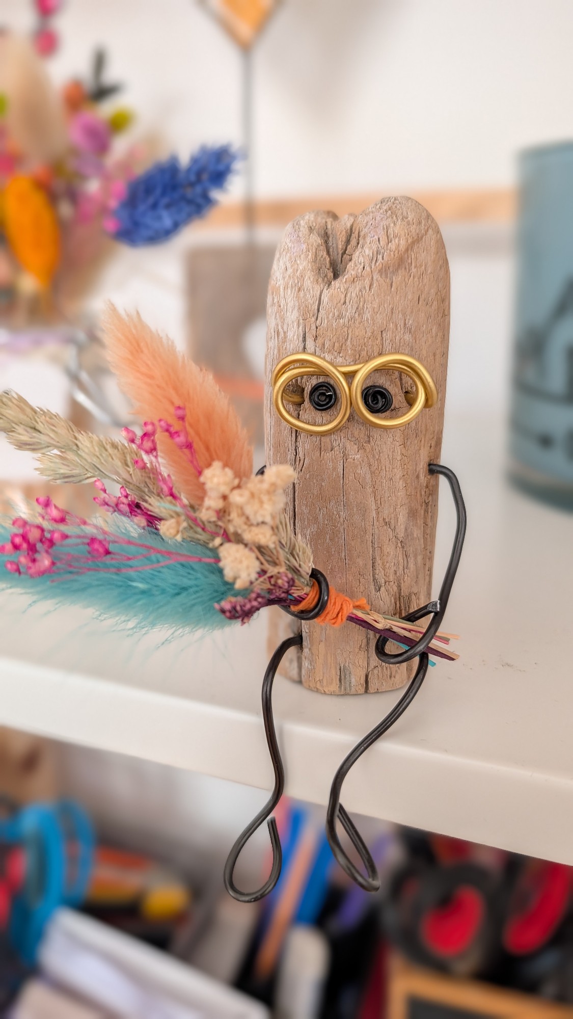 Kleine Treibholzfigur mit Drahtbrille und Trockenblumenstrauß