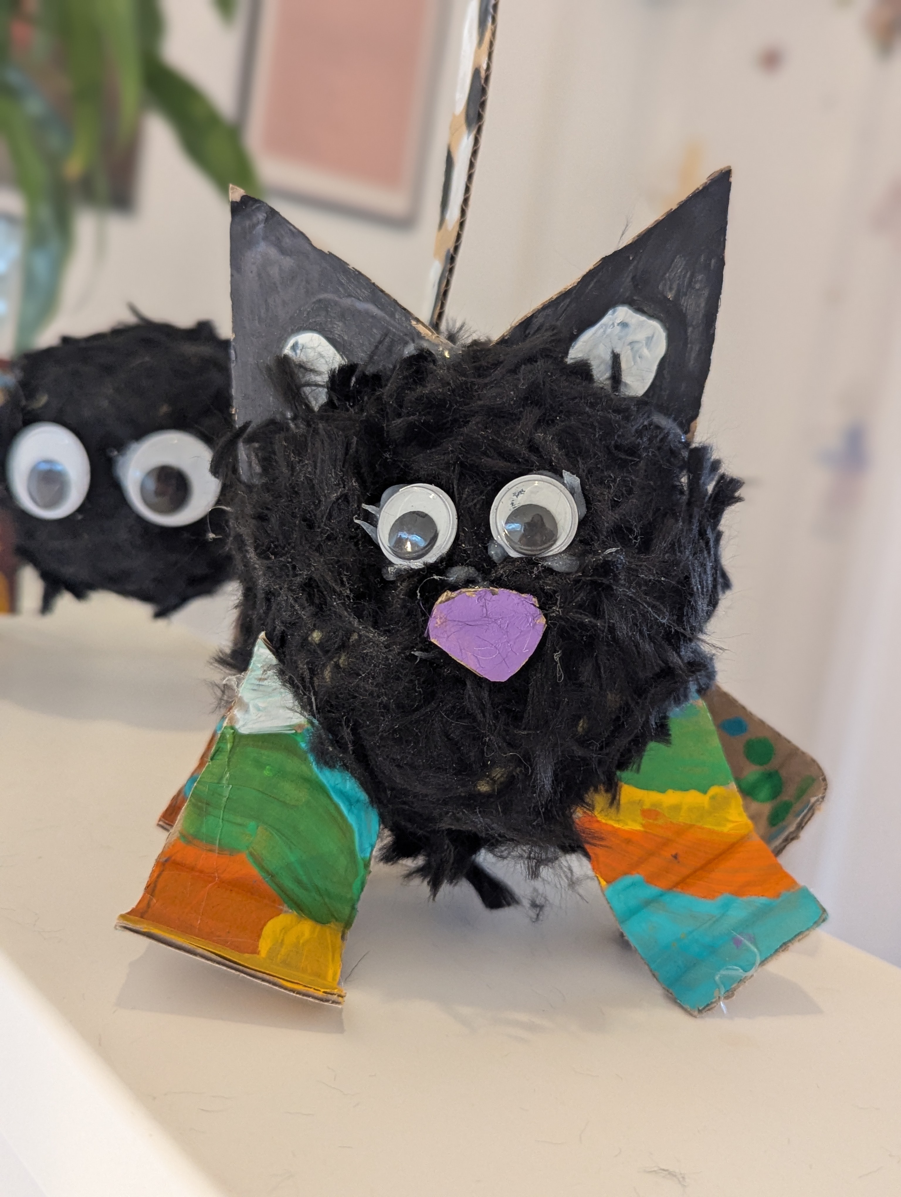 Selbstgebastelte Katze aus Wolle und bemalter Pappe mit Wackelaugen