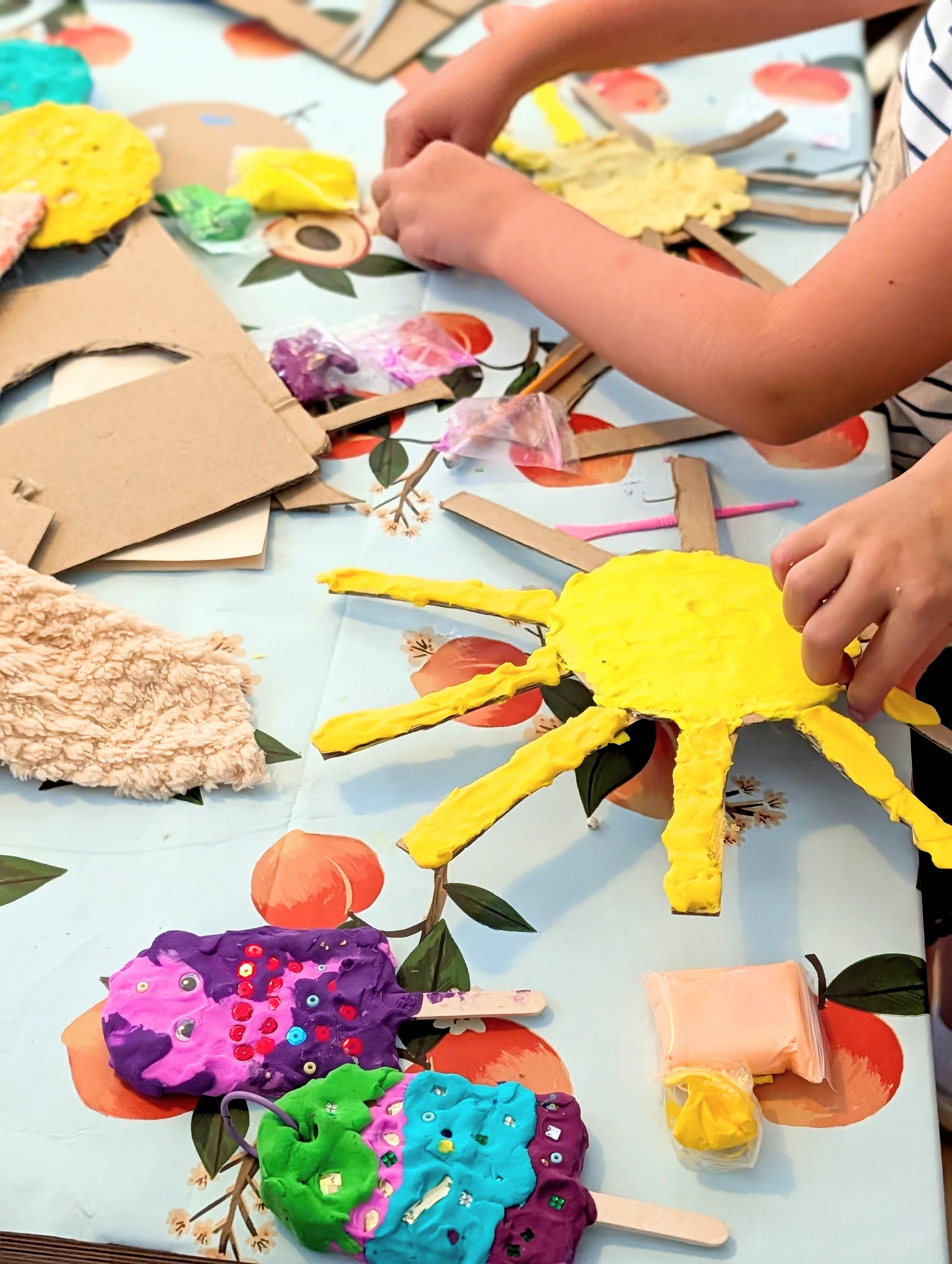 Kind formt und bemalt bunte Figuren aus Modelliermasse