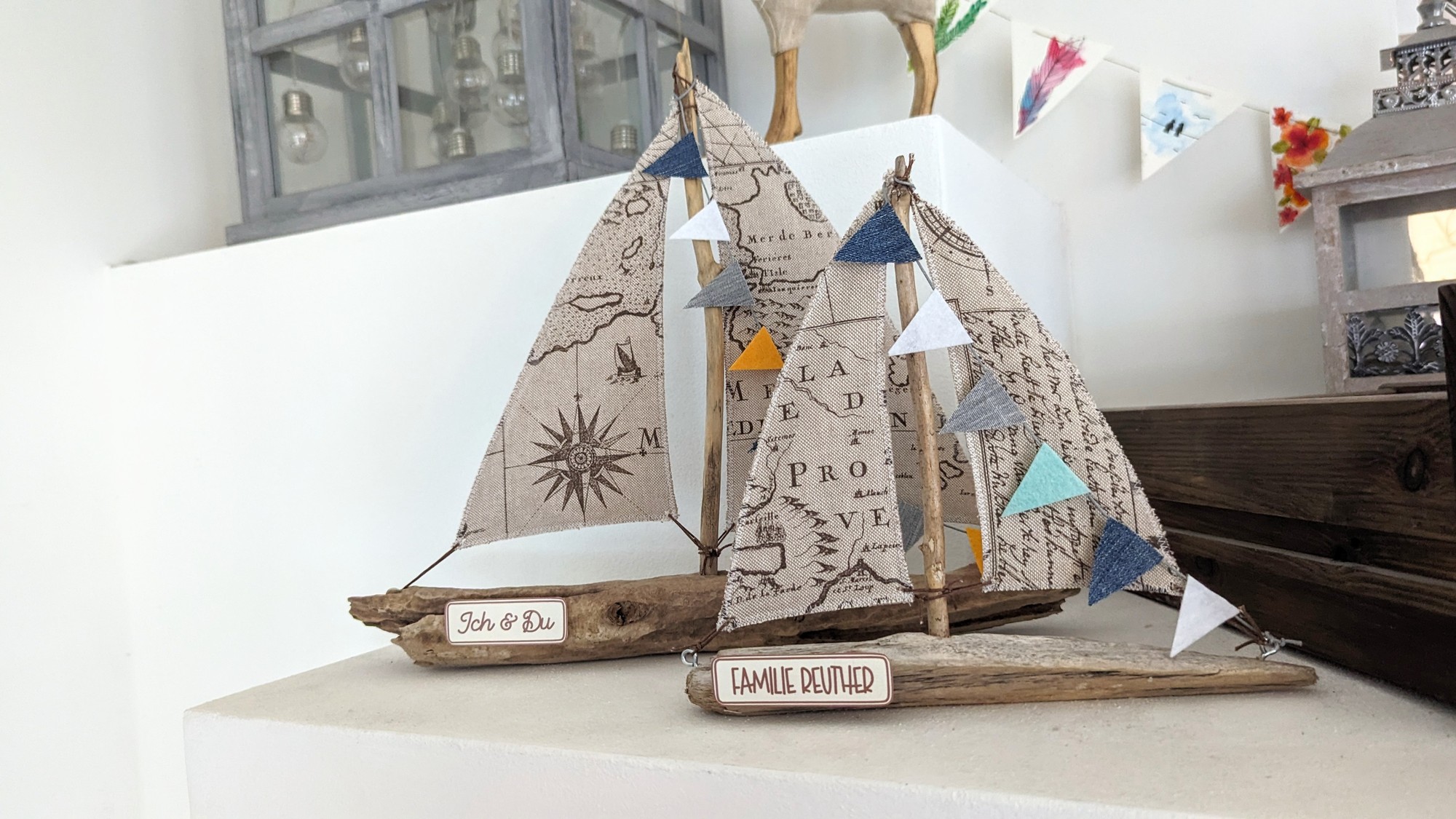 Zwei personalisierte Treibholzboote mit Namensschildern „Ich & Du“ und „Familie Reuther“