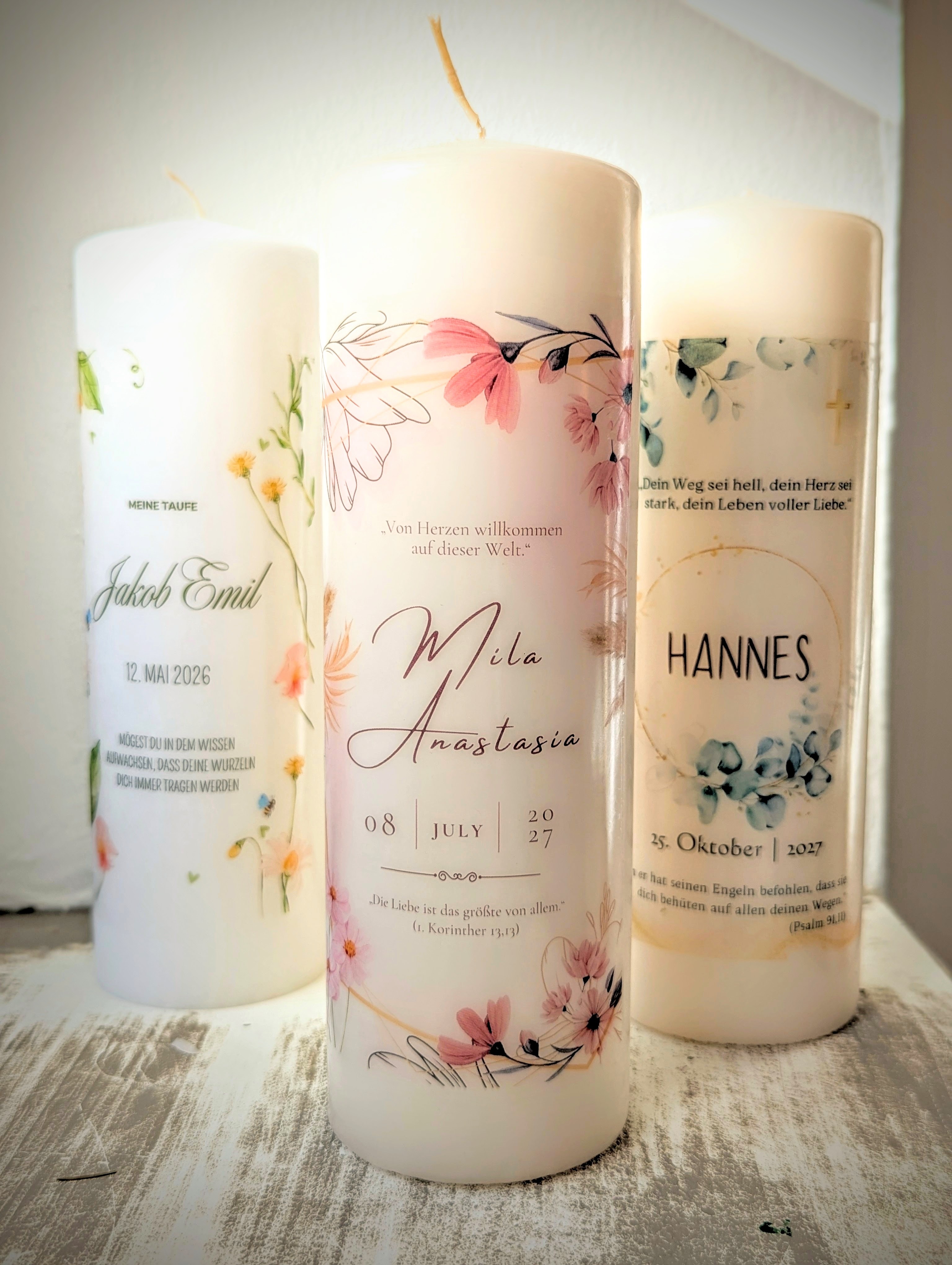 Drei personalisierte Tauf- und Hochzeitskerzen mit Blumenmotiven und Namen